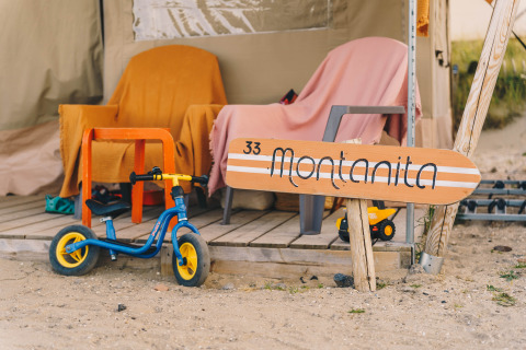 Alojamiento glamping en Surfana Family Camp Bloemendaal, Holanda del Norte, con bici infantil y terraza.