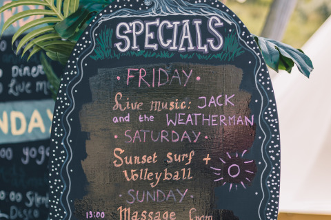 Tableau des offres spéciales au Surfana Family Camp Bloemendaal - Glamping Noord-Holland avec activités et musique.