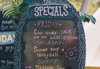 Tableau des offres spéciales au Surfana Family Camp Bloemendaal - Glamping Noord-Holland avec activités et musique.