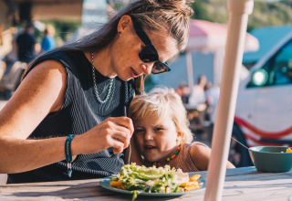 Madre e hijo comparten un almuerzo saludable en el Surfana Family Camp Bloemendaal - Glamping Noord-Holland.