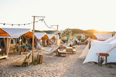 Glamping in de avondzon met tenten, hangmatten en strandsfeer bij Surfana Family Camp Bloemendaal.