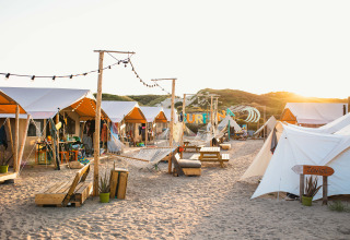 Glamping bei Sonnenuntergang mit stilvollen Zelten und Hängematten im Surfana Family Camp Bloemendaal.