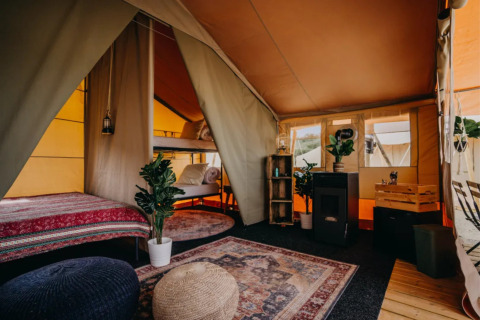 Indvendigt glamping-telt ved Surfana Family Camp Bloemendaal med hyggelig indretning og sovepladser.