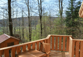 Aussicht von einer Holzterrasse beim Baumhaushotel Solling - Boomhut Nedersaksen, im Wald gelegen.