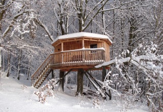 Baumhaushotel Solling im verschneiten Wald, Glamping-Unterkunft in Niedersachsen im Winter.