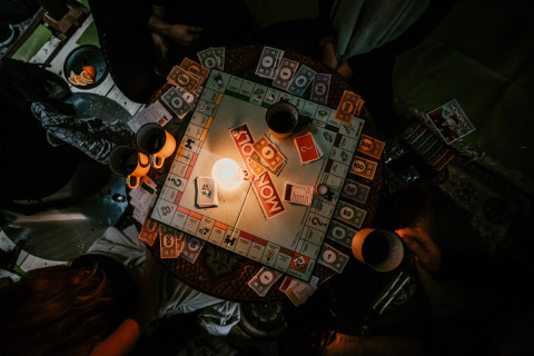 Gezellige avond bij Winterwoods - Yurts Drenthe, Monopoly spelen bij kaarslicht met warme drankjes.