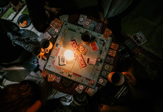 Gezellige avond bij Winterwoods - Yurts Drenthe, Monopoly spelen bij kaarslicht met warme drankjes.