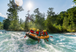 Gruppe beim Wildwasser-Rafting nahe Huttopia Bourg-Saint-Maurice - Glamping Savoie an sonnigem Tag.