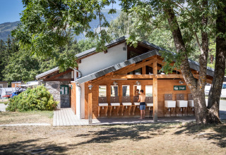Espace de lavage extérieur au glamping Huttopia Bourg-Saint-Maurice en Savoie, entouré de verdure.