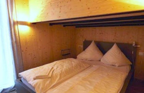 Gemütliches Schlafzimmer im Wellnester Camping bei Losheim am See, Tiny Houses Saarland mit Holzdekor.