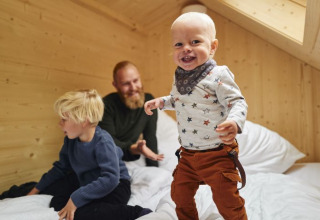 Una famiglia si diverte in una tiny house accogliente al Wellnester Camping vicino Losheim am See.