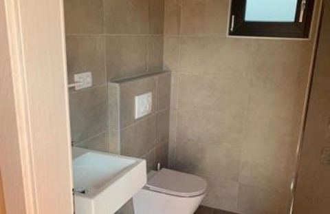 Salle de bain moderne avec toilettes murales et petit lavabo au Wellnester Camping près de Losheim am See.