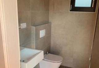 Baño moderno con inodoro de pared y lavabo pequeño en Wellnester Camping cerca de Losheim am See - Tiny houses.