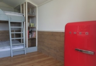 Interieur van Agriturismo Camping Le Marche & Villa Ti Amo - Glamping Le Marche met stapelbed en rode koelkast.