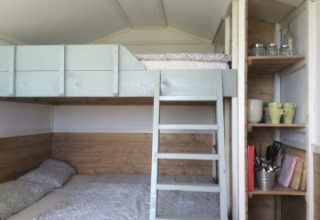 Interieur van glamping accommodatie met stapelbed, ladder en planken bij Agriturismo Camping Le Marche.