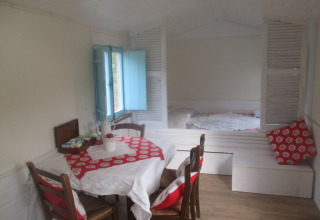 Interno accogliente di Agriturismo Camping Le Marche & Villa Ti Amo con tavolo da pranzo e letto, stile glamping.
