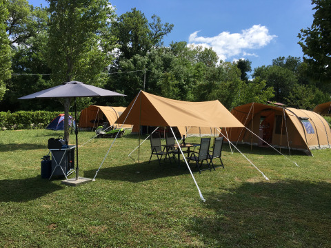 Glampingplatz von Agriturismo Camping Le Marche & Villa Ti Amo mit Zelten und Gartenmöbeln im Grünen.