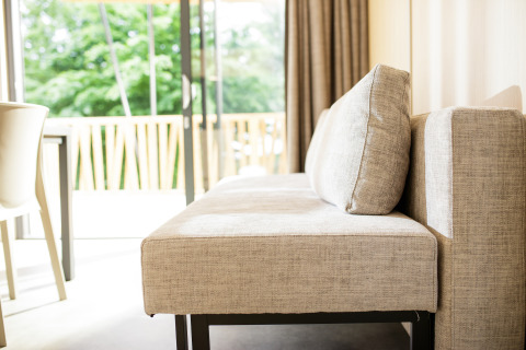 Moderne Sofa mit Blick auf Terrasse und grüne Natur im Glamping-Lodge Camping Pré Fixe in den Pyrenäen.