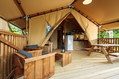 Alojamiento glamping con terraza de madera, comedor exterior y cocina en Camping Pré Fixe, Pirineos.