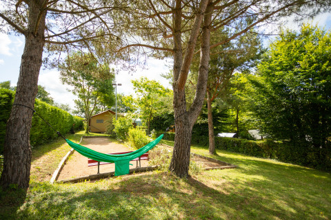 Grüne Hängematte zwischen Bäumen auf Camping Pré Fixe - Lodges in den Pyrenäen, friedliche Umgebung.
