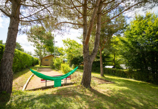 Grüne Hängematte zwischen Bäumen auf Camping Pré Fixe - Lodges in den Pyrenäen, friedliche Umgebung.