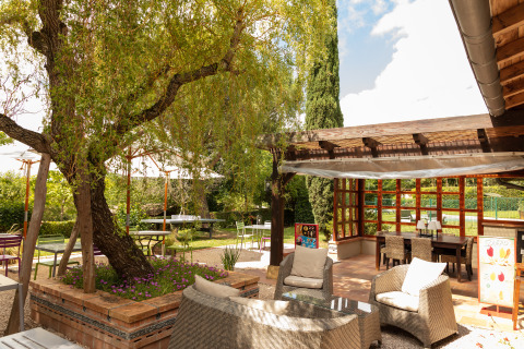 Buitenlounge bij Camping Pré Fixe - Lodges in de Pyreneeën met tuinmeubels en groene omgeving.