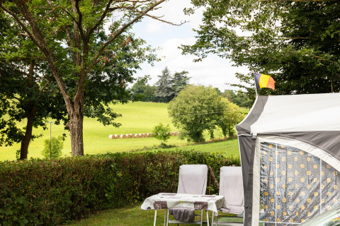 Camping Pré Fixe : hébergement glamping avec tente, chaises et vue sur la campagne des Pyrénées.