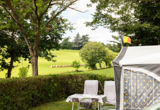 Camping Pré Fixe: Glampingaccommodatie met tent, stoelen en uitzicht op velden in de Pyreneeën.