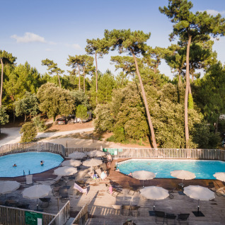 Schwimmbäder bei Huttopia Oléron les Pins Glamping in Nouvelle-Aquitaine, umgeben von grünen Pinienwäldern.