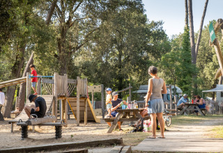 Des familles profitent des jeux et de la détente au camping Huttopia Oléron les Pins, espace glamping convivial.