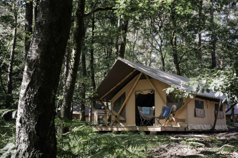 Spacious glamping tent surrounded by lush forest at Huttopia Lac de Sillé, Glamping Pays de la Loire.