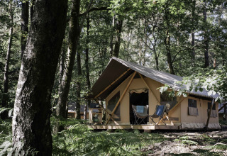 Alojamiento glamping en gran tienda rodeada de bosque en Huttopia Lac de Sillé, Glamping Pays de la Loire.