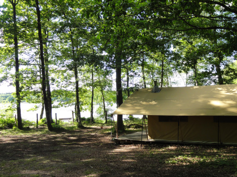 Alojamiento glamping junto al lago en el bosque en Huttopia Lac de Sillé, Glamping Pays de la Loire, Francia.