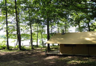 Alojamiento glamping junto al lago en el bosque en Huttopia Lac de Sillé, Glamping Pays de la Loire, Francia.