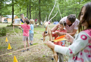 Kinderen leren boogschieten bij Huttopia Lac de Sillé - Glamping Pays de la Loire, glampingcamping in het bos.