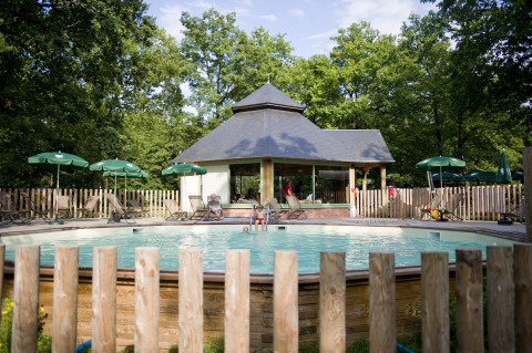Piscina e area relax nel glamping Huttopia Lac de Sillé, Pays de la Loire, immerso nella natura.