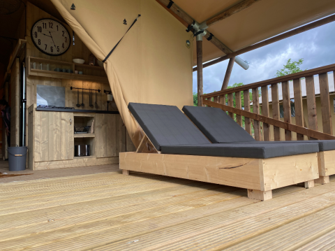 Outdoor wooden deck with two loungers and kitchenette at Azur Camping Altmühle Nature Lodge in Kipfenberg, Bavaria.