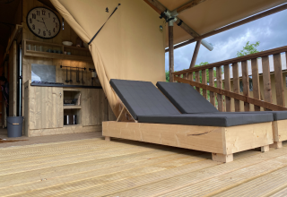 Holzterrasse mit zwei Liegen und offener Küche in der Glamping-Unterkunft Azur Camping Altmühle in Kipfenberg.