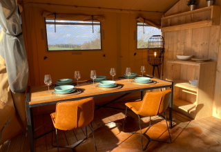 Interno di tenda glamping ad Azur Camping Altmühle, Nature Lodge Baviera, con tavolo da pranzo apparecchiato.