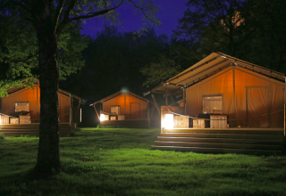 Beleuchtete Glamping-Zelte im Azur Camping Altmühle (Kipfenberg) Nature Lodge Beieren bei Nacht im Grünen.
