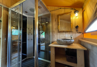 Modernes Badezimmer mit Glasdusche, Steinschale und Spiegel in der Nature Lodge bei Azur Camping Altmühle.