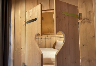 Casetta in legno con porta decorata a cuore, letto all’interno, glamping Azur Camping Altmühle, Kipfenberg.