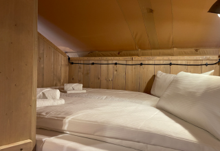 Cozy sleeping area with double bed and wooden walls at Azur Camping Altmühle Nature Lodge in Bavaria.