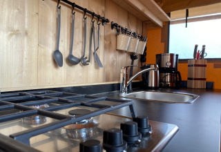 Cucina moderna in lodge glamping ad Azur Camping Altmühle con fornello a gas, lavello e utensili.