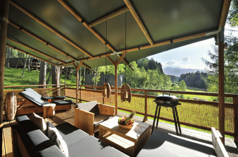 Luxury glamping at Nature Resort Natterer See - Safarilodges Tirol with deck, lounge seating, and mountain view.