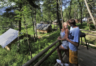 Pareja disfrutando de la vista desde una terraza en Nature Resort Natterer See - Safarilodges Tirol, entre bosques.