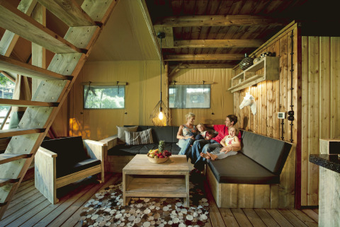 Familie hygger sig i glamping-indkvartering på Nature Resort Natterer See - Safarilodges Tirol, træinteriør.