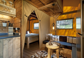 Cozy glamping accommodation at Nature Resort Natterer See Safarilodges Tirol with wooden interior and sofa.