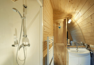 Moderne badkamer met houten wanden en douche in Nature Resort Natterer See - Safarilodges Tirol.