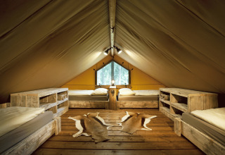 Sfeervolle glampingaccommodatie bij Nature Resort Natterer See, Safarilodges Tirol met vier houten bedden.